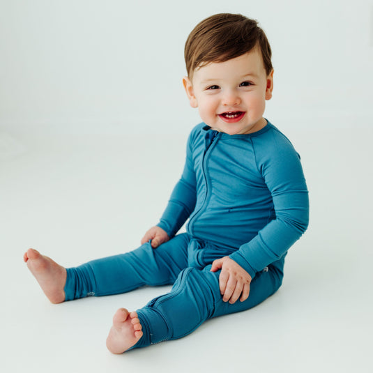 Baby wearing Blue Charcoal bamboo baby pajamas, a modern and cozy baby onesie made for comfort. A gender-neutral favorite in bamboo baby clothes and a perfect baby shower gift.