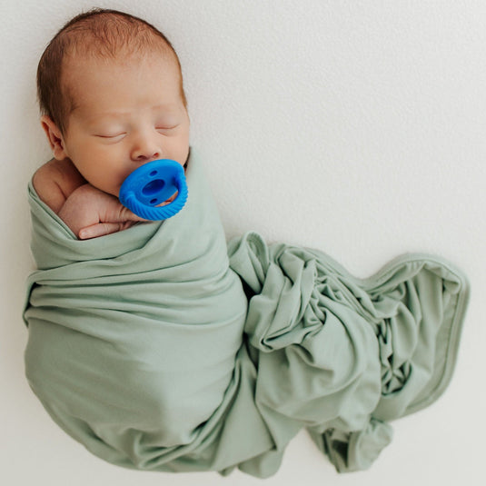 Baby snugly wrapped in one of our Frosted Sage Stretchy Swaddle Blankets. A must-have in bamboo baby clothes and for thoughtful Baby Shower Gifts.