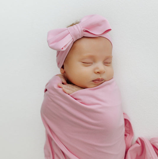 Baby sleeping peacefully in one of our Petal Glow Stretchy Swaddle Blankets. A stylish choice in bamboo baby clothes, perfect for Baby Shower Gifts.