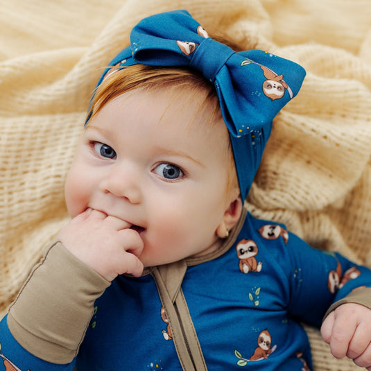 Sleepy Sloth | Baby wearing Sleepy Sloth bamboo baby bow – an ultra-soft option for comfort and style. A top choice in bamboo baby clothes and a perfect baby shower gift.