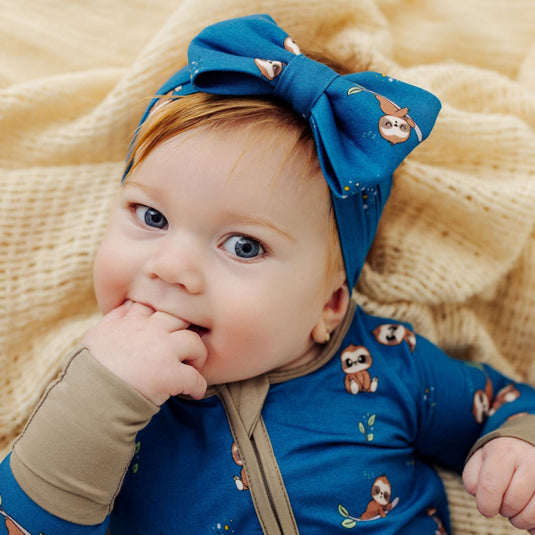 Baby wearing Sleepy Sloth bamboo baby bow – an ultra-soft option for comfort and style. A top choice in bamboo baby clothes and a perfect baby shower gift.