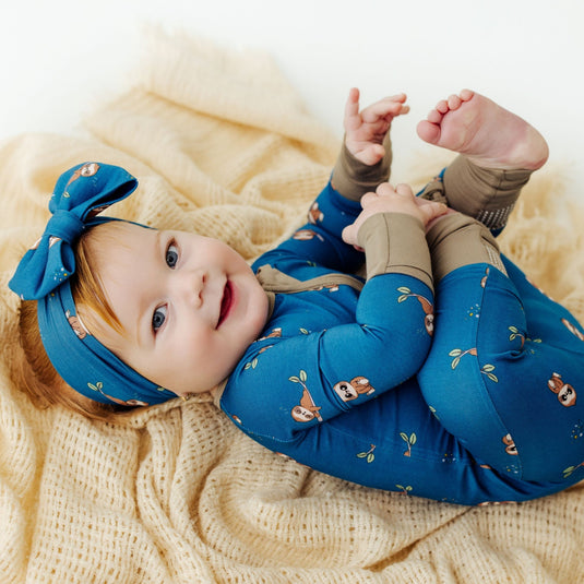 Baby wearing Sleepy Sloth bamboo baby bow – enjoying the ultra-soft and stretchy fabric. A cozy and hypoallergenic must-have in bamboo baby clothes and an elegant baby shower gift.