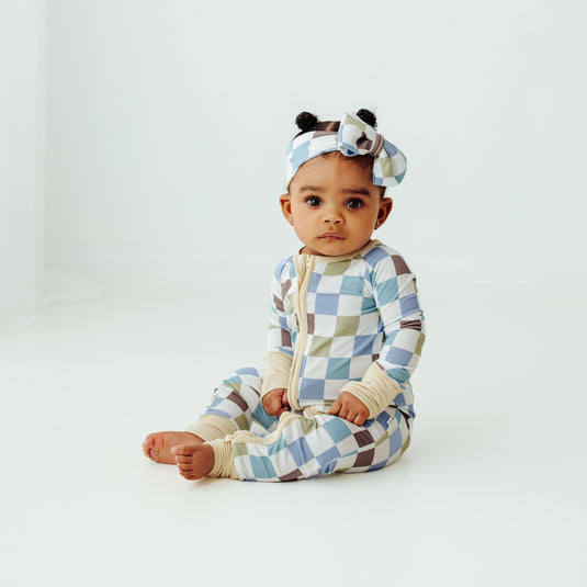 Baby wearing Luxe Checker bamboo baby pajamas, a stylish and breathable baby onesie perfect for everyday wear. A premium pick in bamboo baby clothes and elegant baby shower gifts.