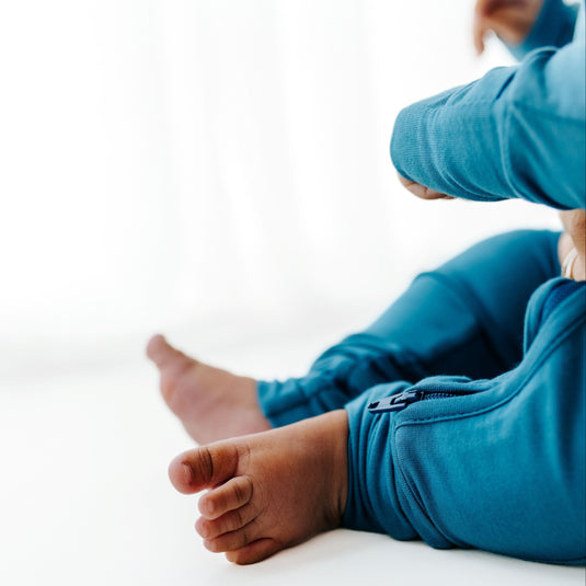 Baby wrapped in Blue Charcoal bamboo baby sleeper with a two-way zipper – luxuriously soft, stretchy, and perfect for sensitive skin. These baby sleepers are a must-have in bamboo baby clothes for stylish parents.