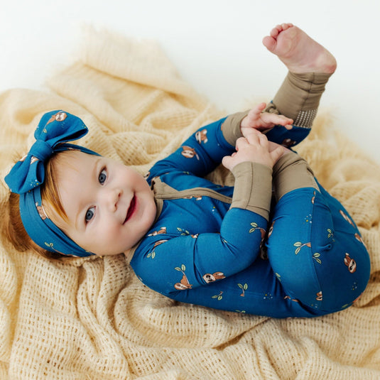 Baby cuddled up in Sleepy Sloth bamboo baby sleeper – a luxuriously soft sleeper designed for ultimate comfort. A top pick in bamboo baby clothes and an ideal baby shower gift.