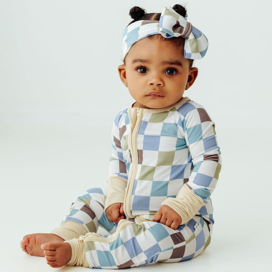 Baby wearing Luxe Checker bamboo sleeper – a stylish and breathable sleeper perfect for everyday wear. These baby sleepers are a premium pick in bamboo baby clothes and an elegant baby shower gift.