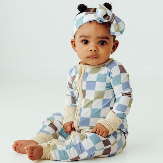 Baby wearing Luxe Checker bamboo sleeper – a stylish and breathable sleeper perfect for everyday wear. These baby sleepers are a premium pick in bamboo baby clothes and an elegant baby shower gift.