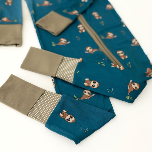 Teal fabric with sloth patterns and brown accents on a white background