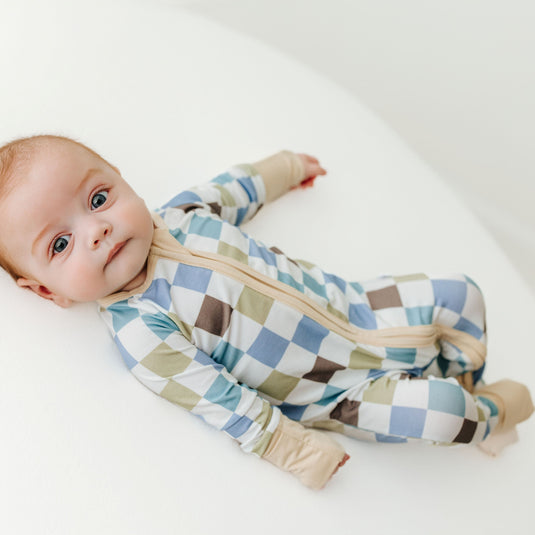 Baby wearing a checkered onesie on a white background