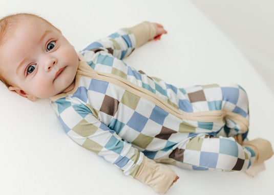 Baby wearing a checkered onesie on a white background