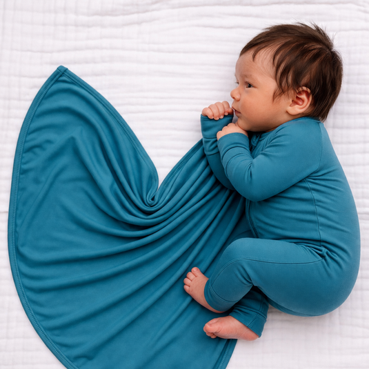 Newborn baby wearing blue preemie bamboo sleeper and swaddle for cozy, comfortable early moments