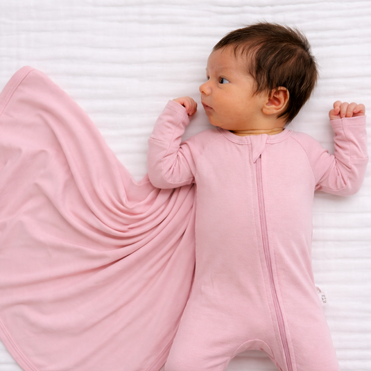 Newborn baby in pink preemie bamboo sleeper and swaddle designed for comfort in the earliest days