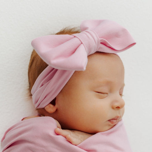 Baby napping in Petal Glow bamboo bow headband – designed for ultimate comfort. A perfect accessory to pair with our bamboo baby clothes and an ideal baby shower gift.