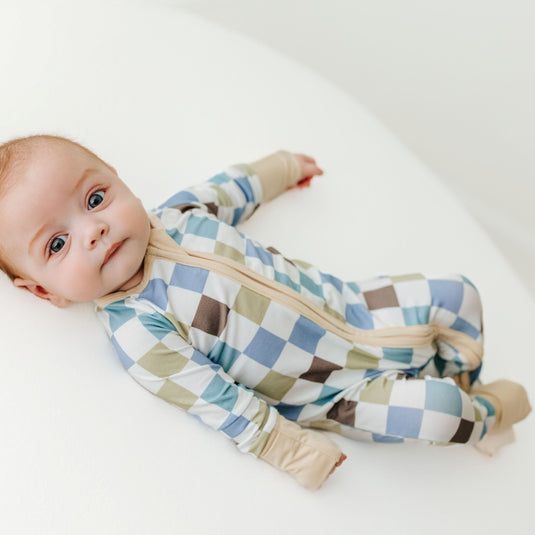 Baby wearing a checkered onesie on a white background