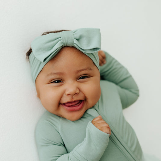 Frosted Sage | Baby laughing in Frosted Sage bamboo baby bow – a premium addition to bamboo baby clothes and a thoughtful baby shower gift.