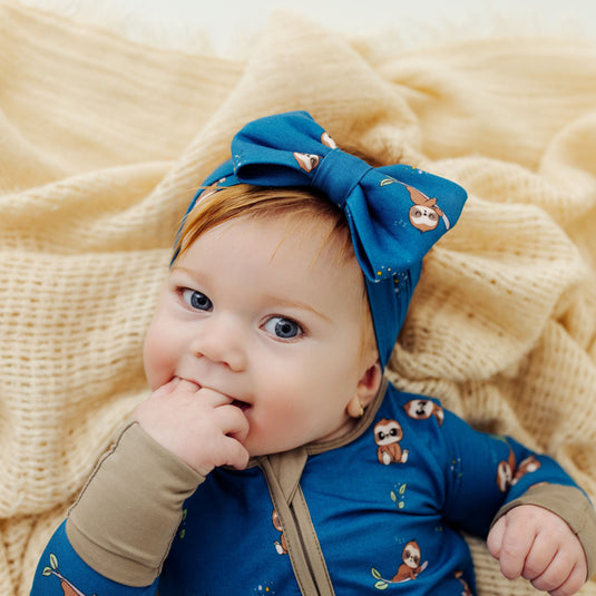 Baby wearing our Sleepy Sloth bamboo baby bows, an ultra-soft option for comfort and style. A top choice in bamboo baby clothes and perfect baby shower gifts.