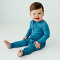 Baby wearing Blue Charcoal bamboo baby pajamas, a modern and cozy baby onesies made for comfort. A gender-neutral favorite in bamboo baby clothes and a perfect baby shower gift.