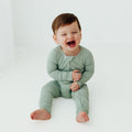 Baby laughing in Frosted Sage bamboo baby pajamas, a cozy and hypoallergenic baby onesies perfect for delicate newborn skin. A must-have in bamboo baby clothes and for baby shower gifts.