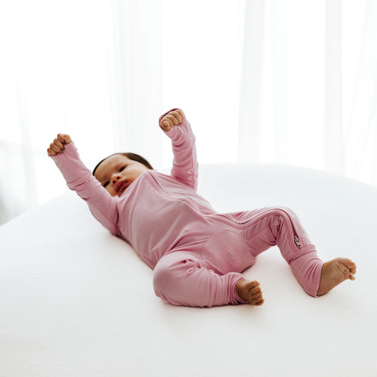 Baby wearing Petal Glow bamboo baby pajamas, a soft and hypoallergenic baby onesies designed for delicate skin. A must-have in bamboo baby clothes and for sweet baby shower gifts.