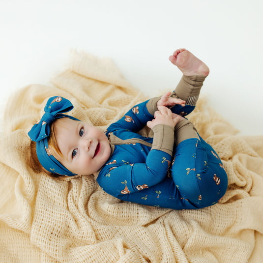 Baby cuddled up in Sleepy Sloth bamboo baby sleeper – a luxuriously soft sleeper designed for ultimate comfort. A top pick in bamboo baby clothes and an ideal baby shower gift.