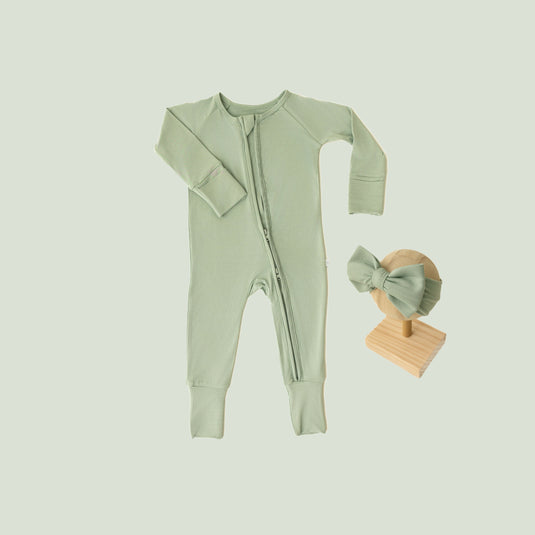 Baby Girl’s Essentials Bundle in Frosted Sage, featuring a breathable bamboo baby pajamas and one of our matching baby bows. A gender-neutral favorite in bamboo baby clothes and perfect for baby shower gifts.