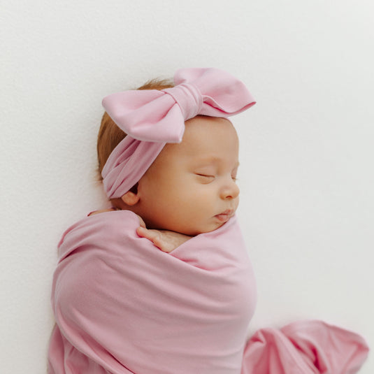 Baby napping in one of our Petal Glow bamboo baby bows, designed for ultimate comfort. A perfect choice to pair with our bamboo baby clothes and ideal for baby shower gifts.